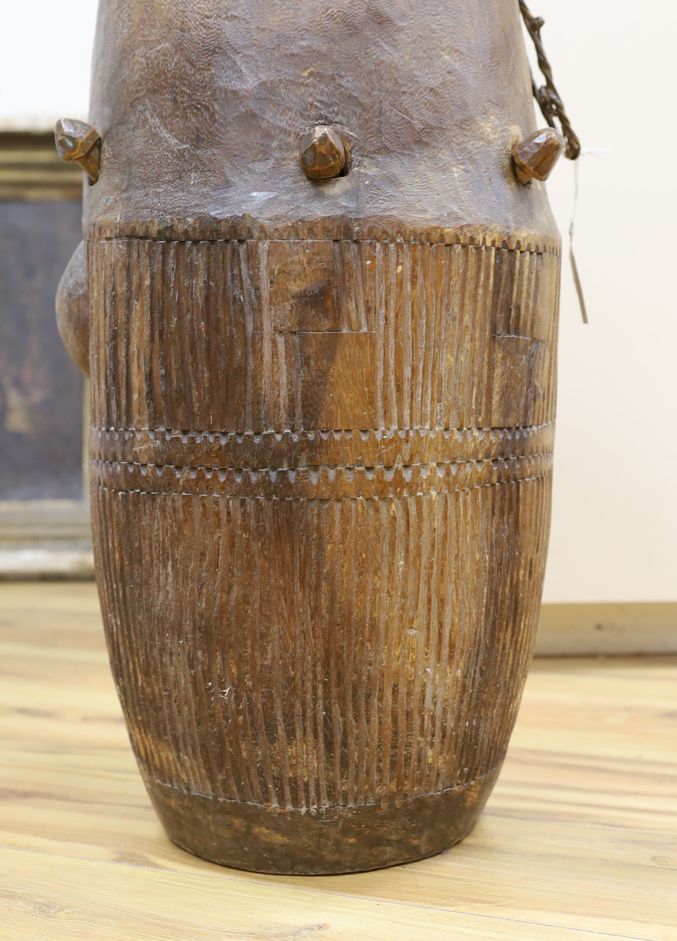 A 19th/20th century Ashanti breasted drum, 61 cms high.